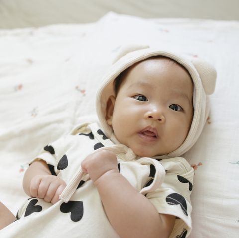 top view  facial expression asian baby girl 0 to 3 month dress up very cute on cozy bed and clear background