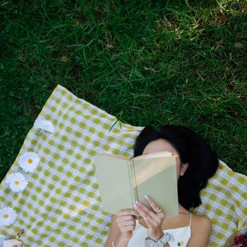 top view of a woman reading a book in the park