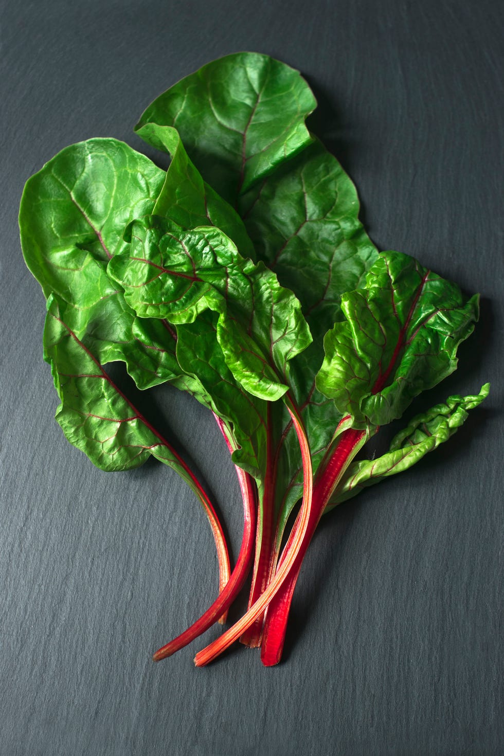 Top view of fresh beet leaves on the dark background