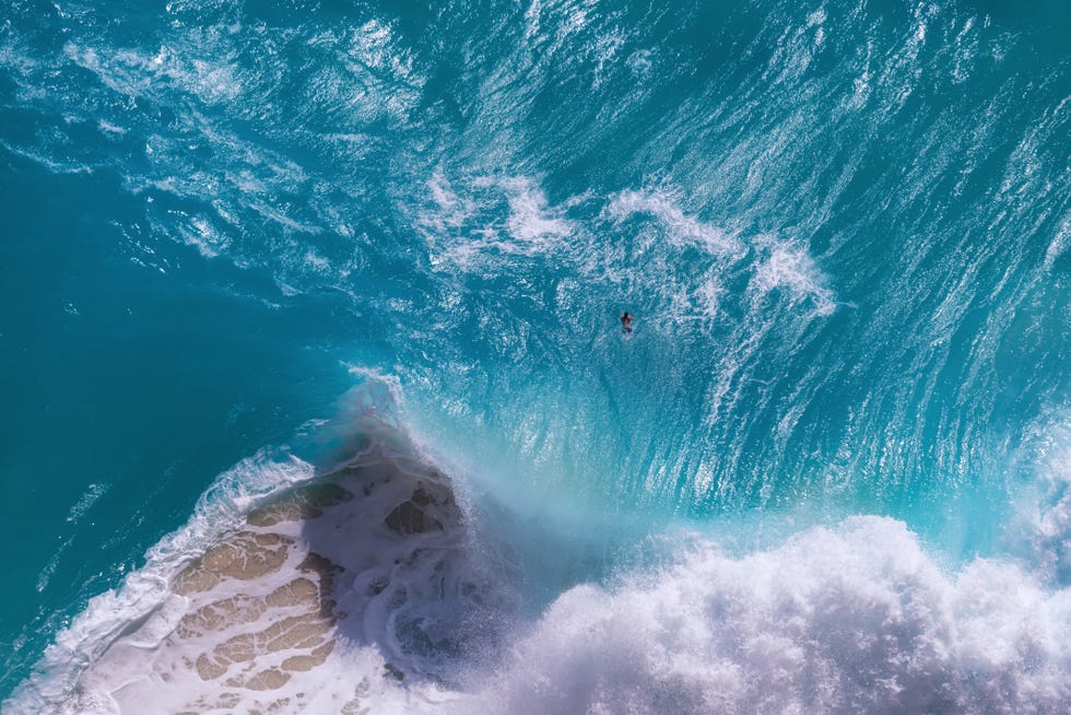 top view of huge ocean waves at kelingking beach, nusa penida island, indonesia