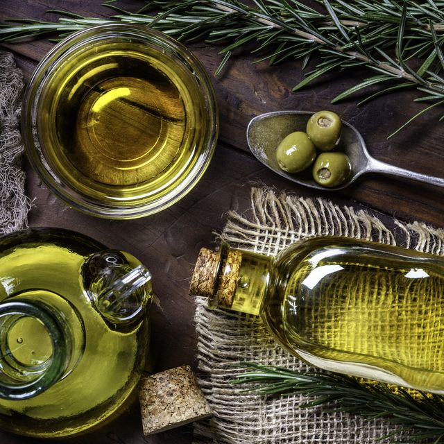 top view of olives and olive oil bottles on table in a rustic kitchen