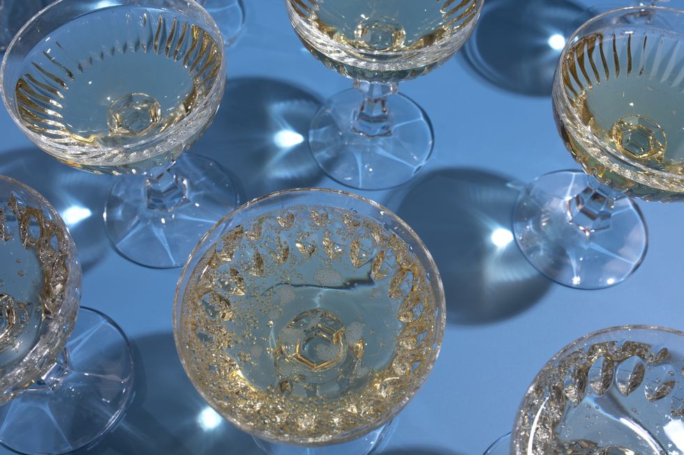 top view of repeated champagne in glasses on the blue background