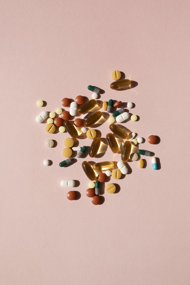 top view of various pills and tablets on the pink background