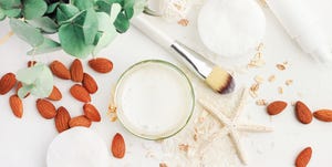 Top view white cosmetic product ingredients, homemade rice water and nut milk facial lotion with almond.