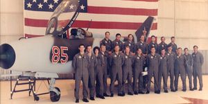 members of the 4477th tactical evaluation squadron standing in front of a mig 21 under evaluation