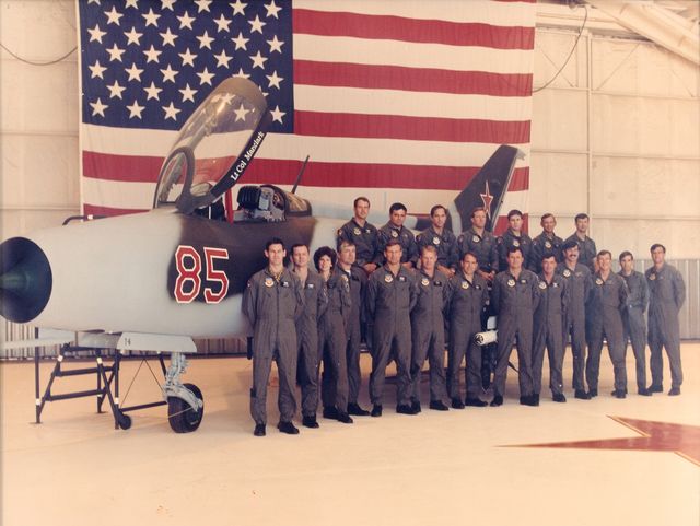 members of the 4477th tactical evaluation squadron standing in front of a mig 21 under evaluation
