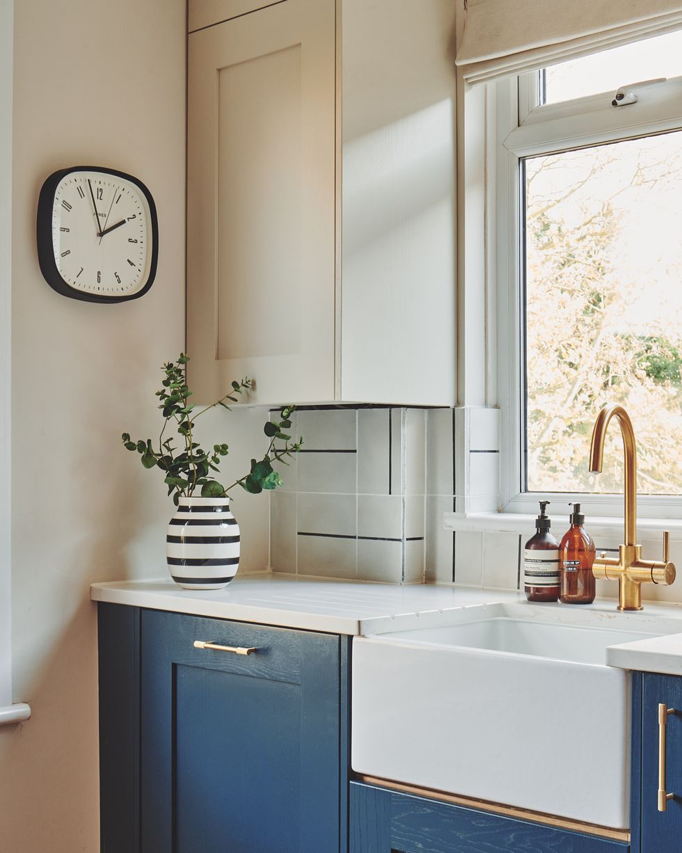 a kitchen with a clock and a plant on the counter