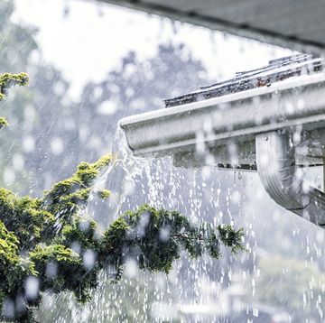 torrential summer rain storm water overflowing roof gutters