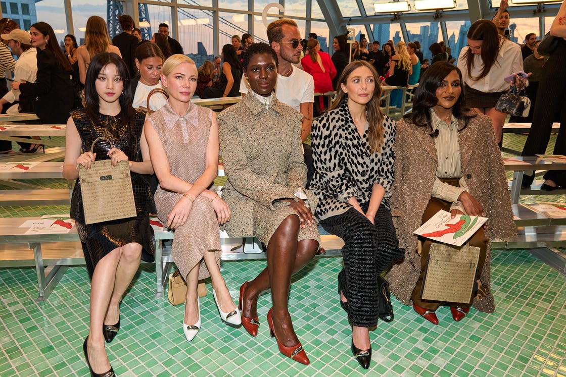 five individuals seated in a fashionable setting attending an event