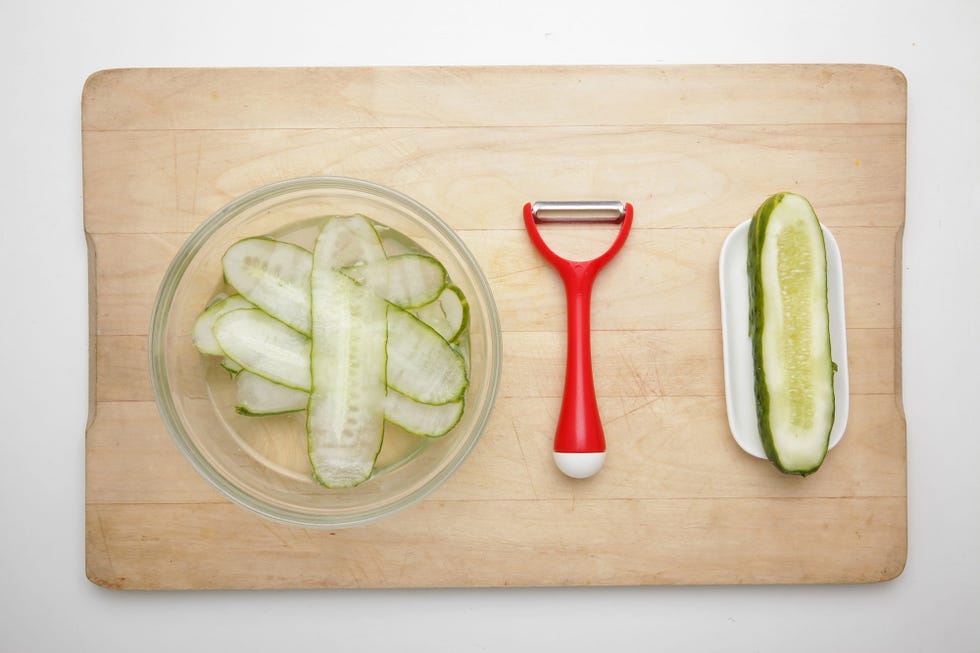 pepino cortada sobre una tabla de madera con un rallador