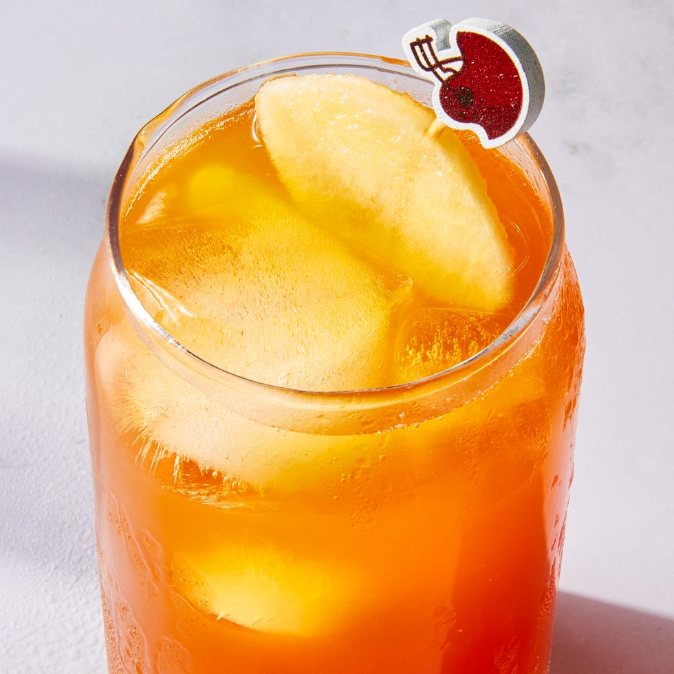 tea in a glass with a peach slice and mini football garnish