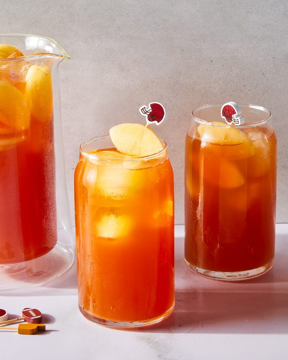 tea in a glass with a peach slice and mini football garnish
