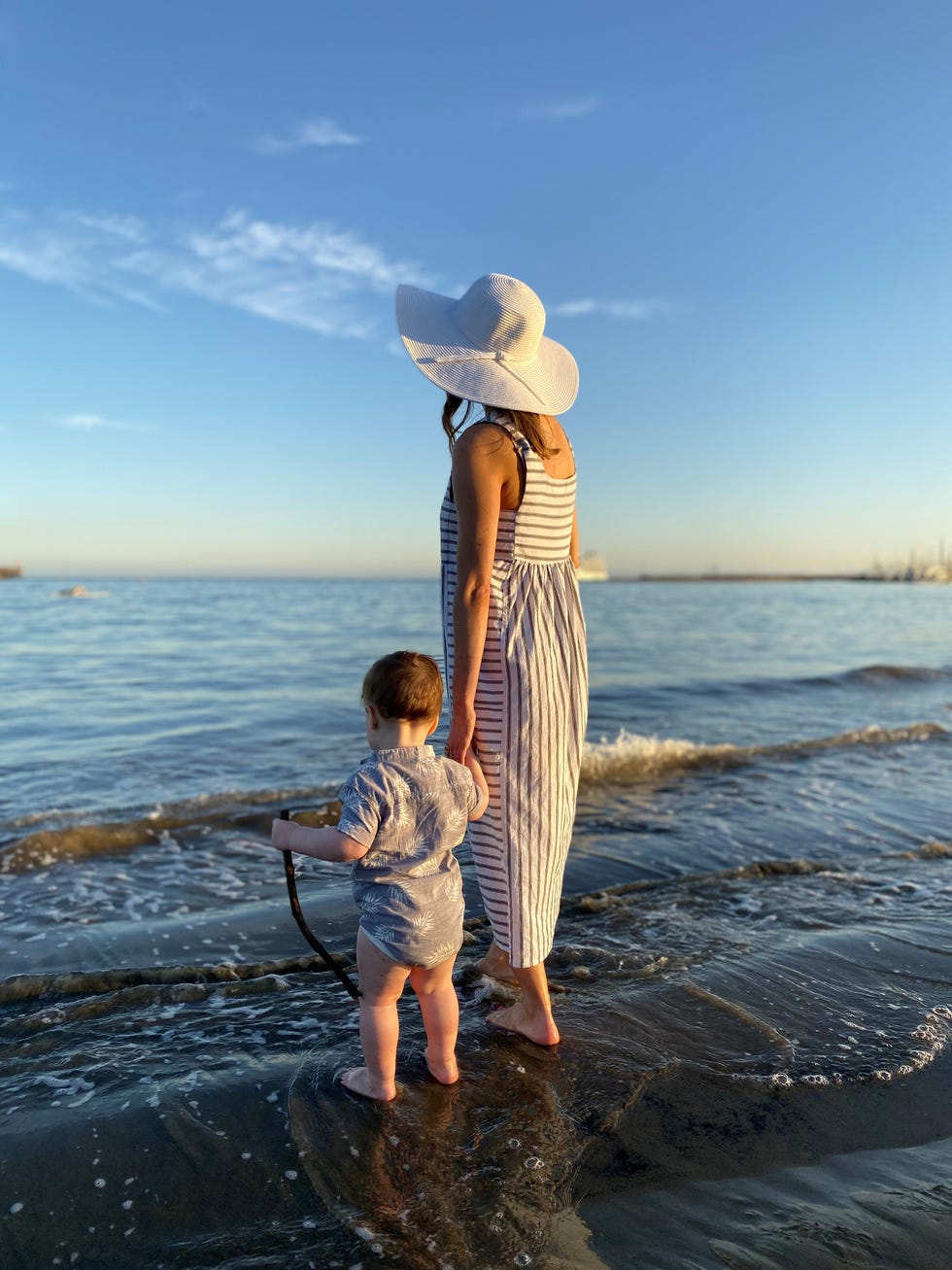 a woman and a child facing the pacific ocean