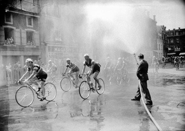 france   march 01  as the tour de france cyclists pass through a small town, they are sprayed with water by a fire hose to help them cool off  photo by keystone francegamma keystone via getty images