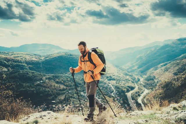 tourist man enjoying nordic walking in the mountain
