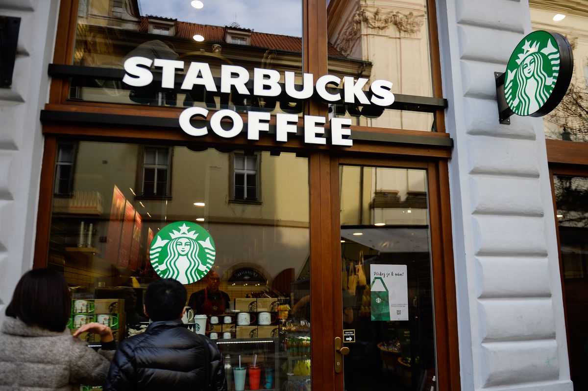 Tourists stand in front of a Starbucks coffee.
  Prague the...