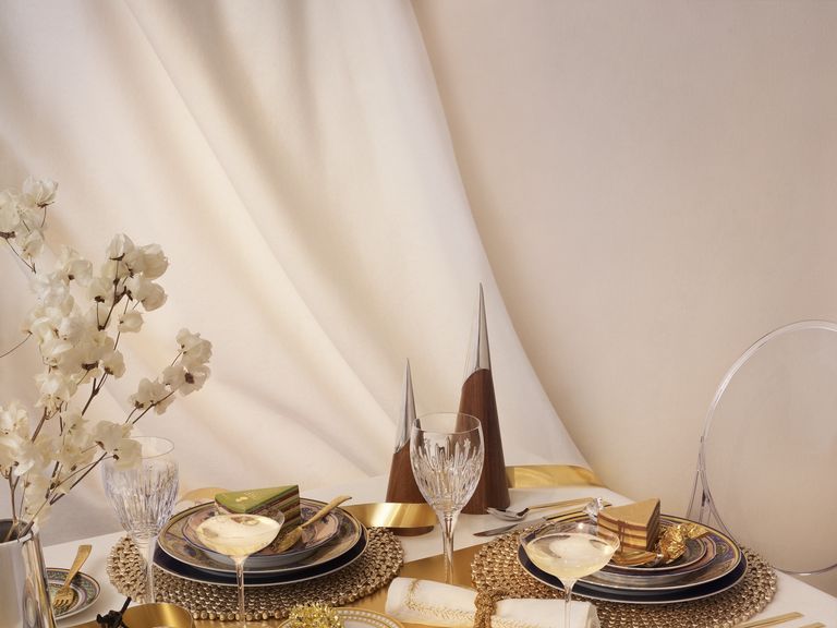 A black tablecloth, expensive utensils and gold details decorate