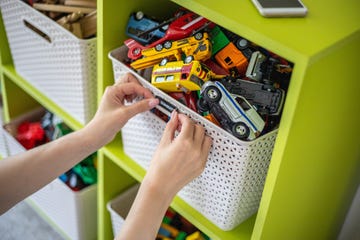 woman hands applying sticker with name title of children toys for storage