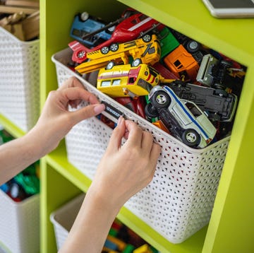 Woman hands applying sticker with name title of children toys for comfortable sorting and storage woman hands applying sticker with name title of children toys for storage