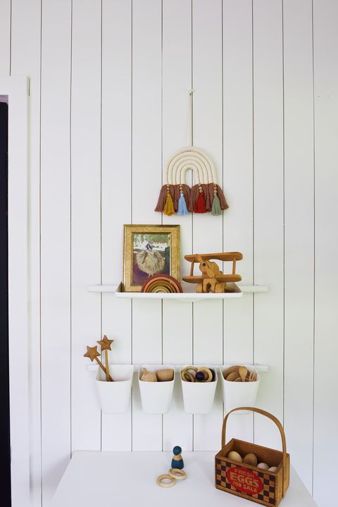 kids’ room shelves and storage bins from ikea hold tiny toys and trinkets the shiplap wall they’re affixed to was a diy project, made using wood paneling