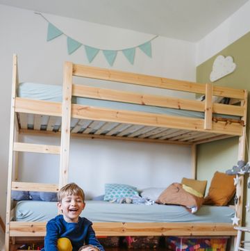 young kids playing on wooden rocker toy in bedroom with bunk beds and tent