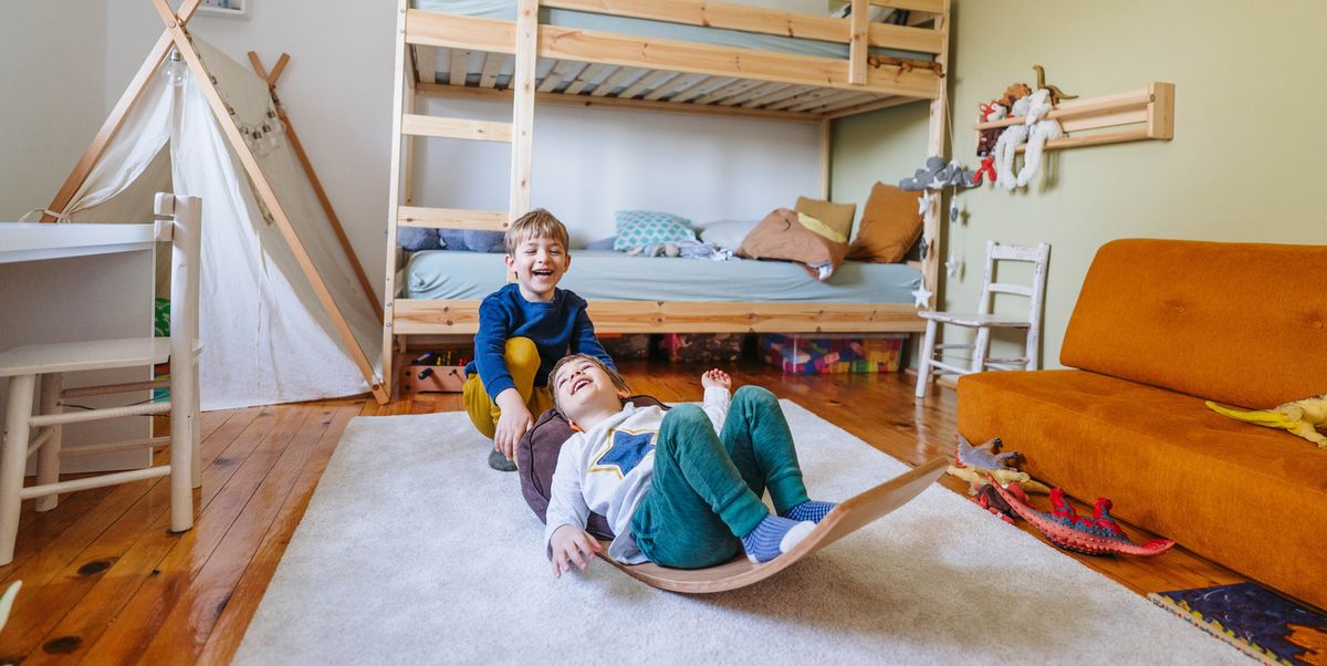 young kids playing on wooden rocker toy in bedroom with bunk beds and tent