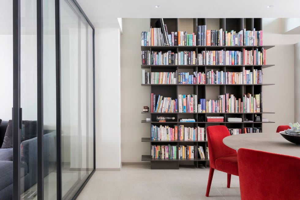 a room with a bookcase and chairs