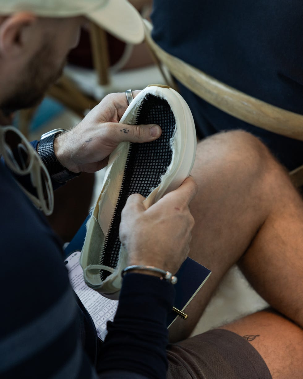 person feeling the inside of the tracksmith eliot racer shoe