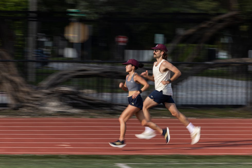 two individuals running on a track in tracksmith eliot racer shoes