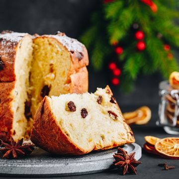 traditional christmas panettone cake with dried fruits on dark stone background