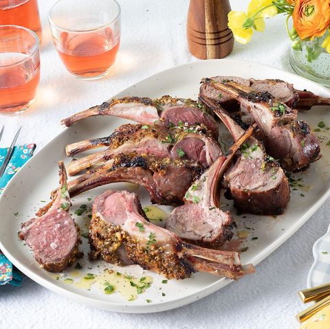 rack of lamb on white platter with rose wine in back