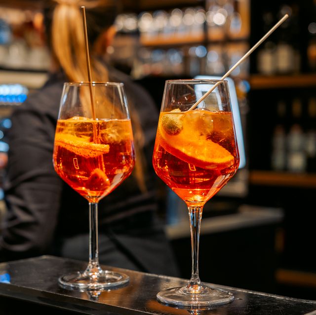 traditional italian cocktail spritz with ice and olives in italian bar, an aperitif in rome, milan venice florence