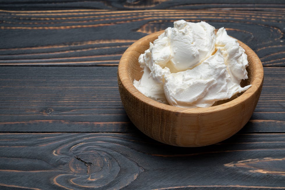 traditional mascarpone cheese in wooden bowl on table
