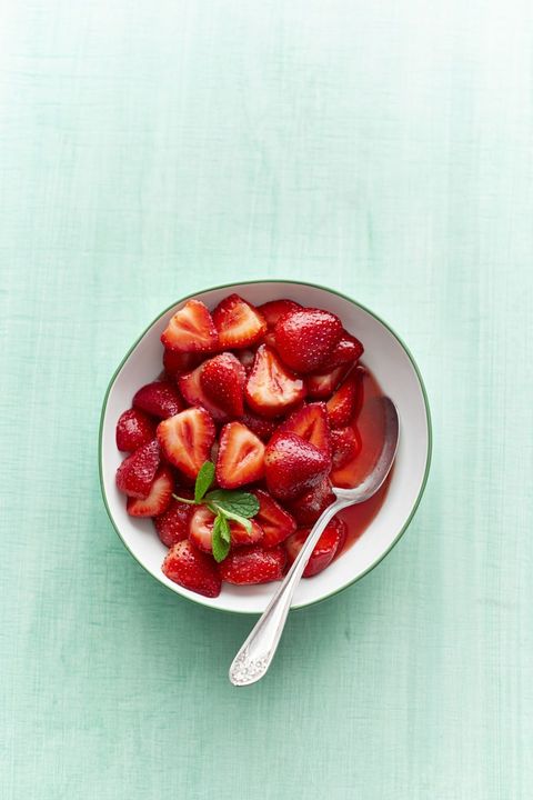 sweet strawberries in bowl with spoon and mint