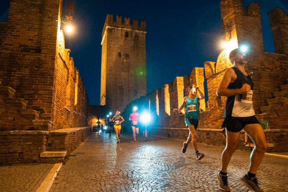 runners participating in a nighttime race near historical architecture