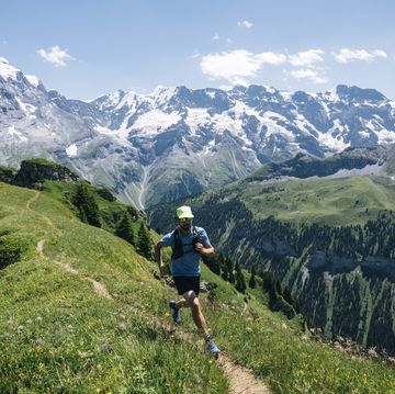 trail runner ascends alpine path in swiss mountain landscape