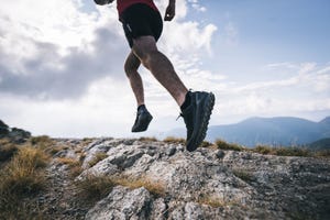 trail runner ascends rocky mountain ridge