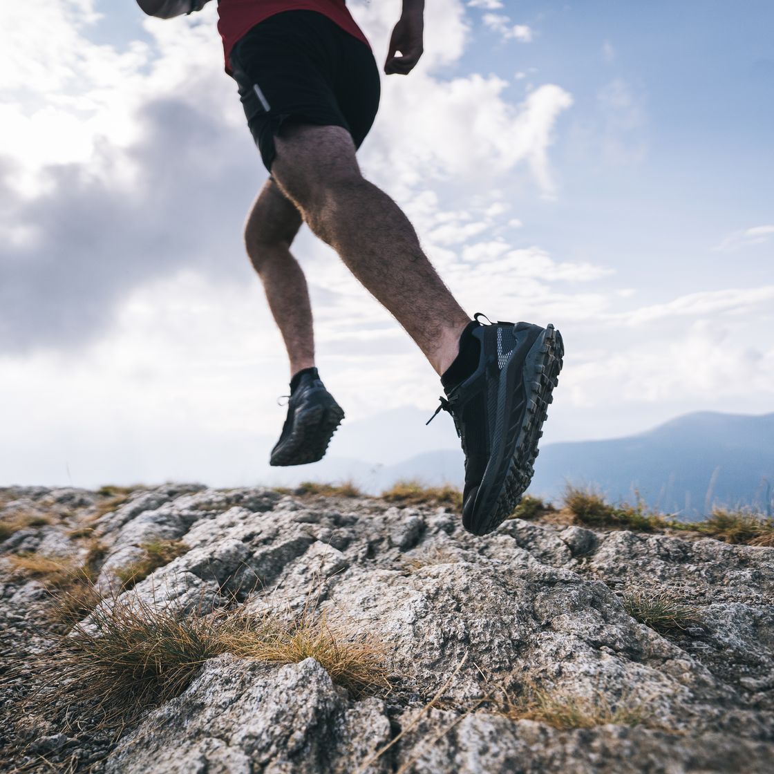 trail runner ascends rocky mountain ridge