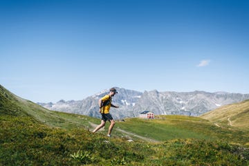 trail runner bounds along mountain trail