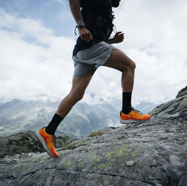 trail runner bounds along mountain trail