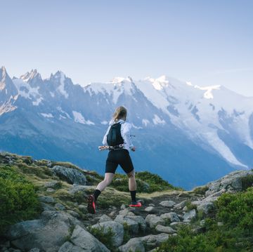 trail runner bounds along mountain trail