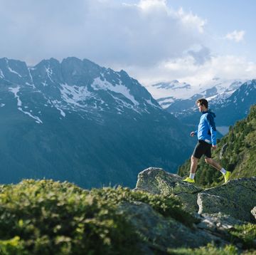 trail runner bounds along mountain trail