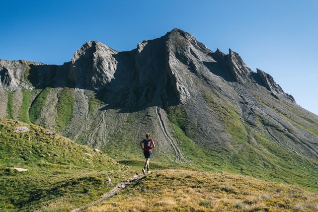 trail runner bounds along mountain trail