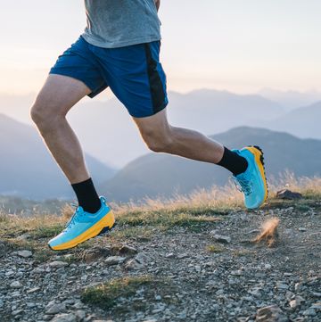 trail runner bounds along mountain trail