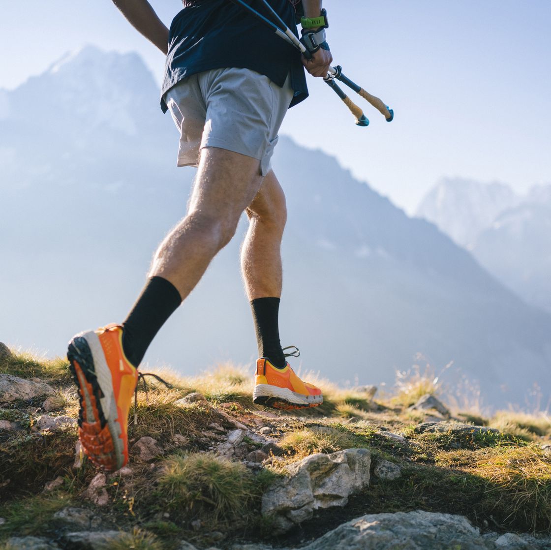 trail runner bounds along mountain trail