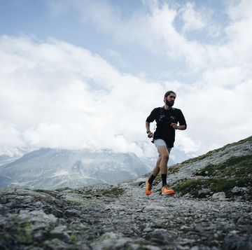 trail runner bounds along mountain trail