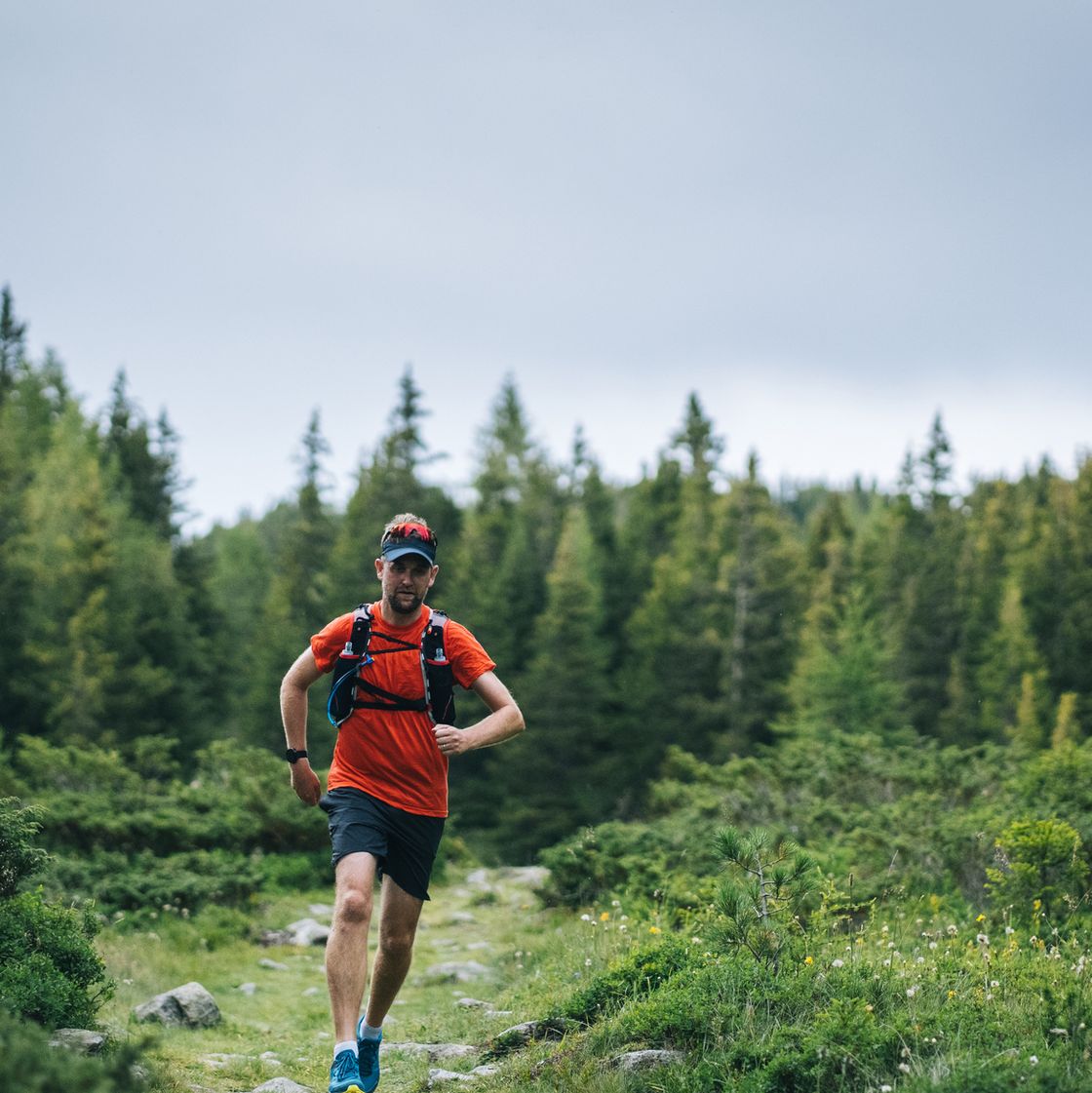 trail runner bounds along mountain trail
