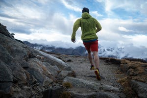 trail runner bounds up mountain trail