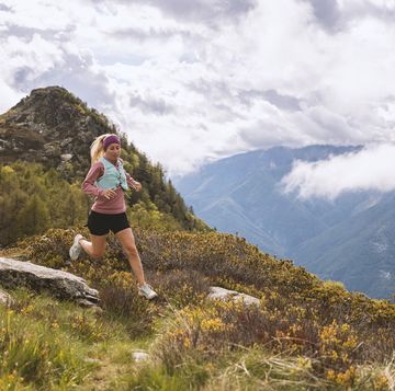 trail runner traverses alpine meadow