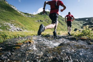 trail runners bound across mountain stream